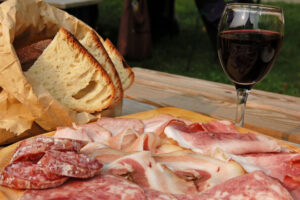 salumeria, un mix di salumi con delle fette di pane fresco e un bicchiere di vino rosso